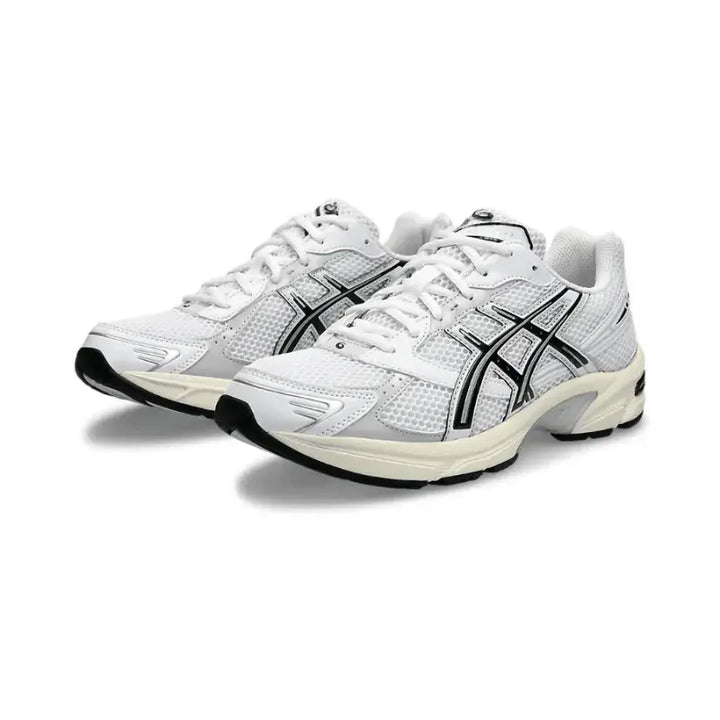 Imagem do ASICS GEL-1130 em ângulo, mostrando o cabedal em mesh e sobreposições prateadas