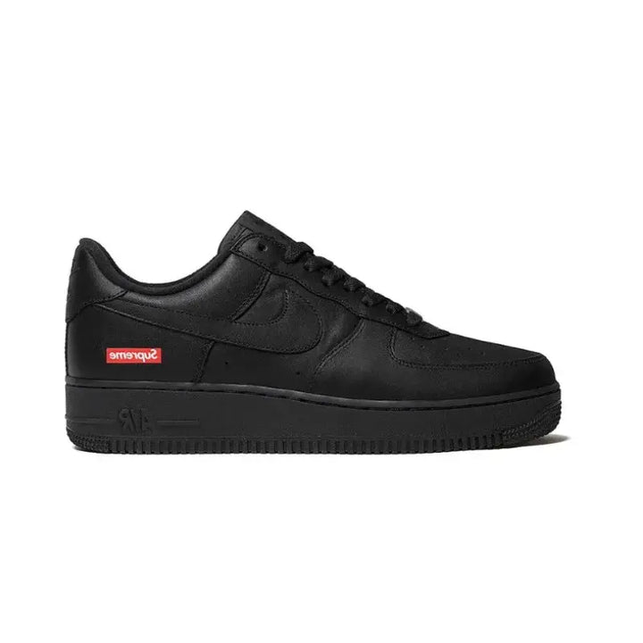 Supreme x Nike Air Force 1 Low Black visto de lado destacando o logo Supreme no calcanhar em vermelho