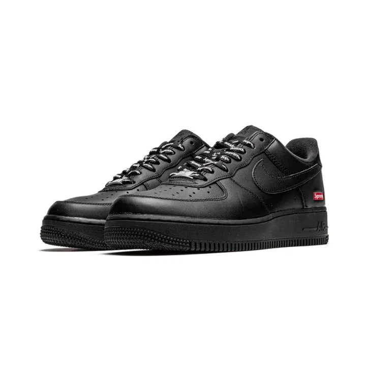 Tênis Supreme x Nike Air Force 1 Low Black em perspectiva frontal com cabedal em couro preto